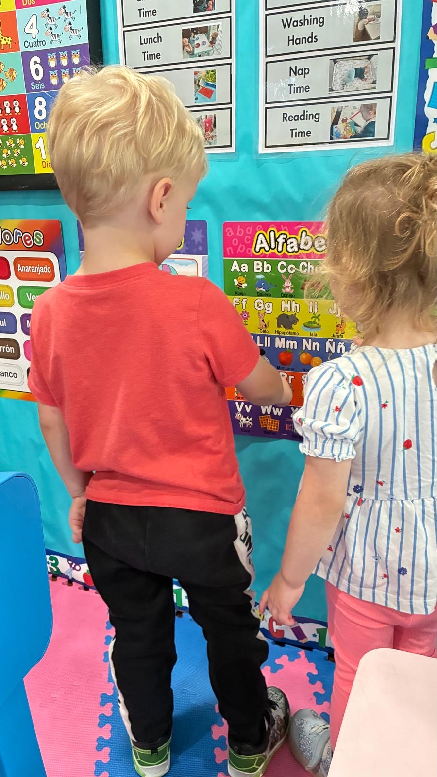 Children learning with alphabet and routine charts indoors